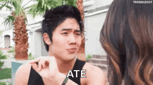 A Man Is Making A Funny Face While Talking To A Woman And Says `` Ate '' . GIF