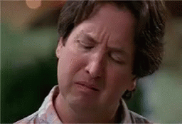 A Man Is Making A Funny Face With His Eyes Closed And His Mouth Open . GIF