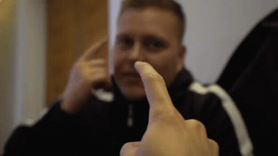 A Man Is Making A Funny Face With His Finger GIF