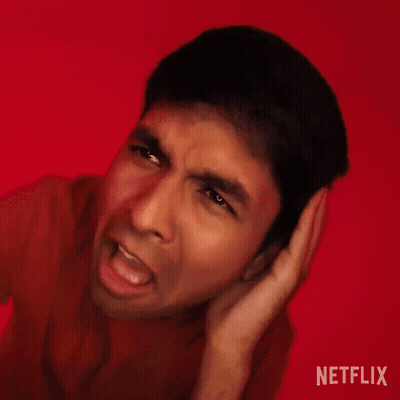 A Man Is Making A Funny Face With His Hands Behind His Ears . GIF