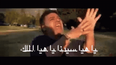 A Man Is Making A Funny Face With His Hands In The Air In Arabic GIF