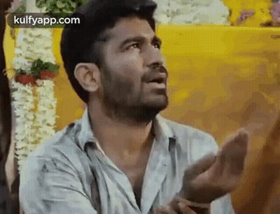 A Man Is Making A Funny Face With His Hands Outstretched . GIF