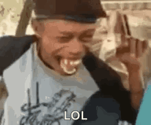 A Man Is Making A Funny Face With His Tongue Out While Wearing A Hat And Smiling . GIF
