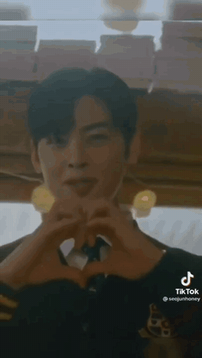 A Man Is Making A Heart Shape With His Hands In A Restaurant . GIF
