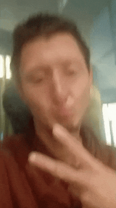 A Man Is Making A Peace Sign With His Hand GIF