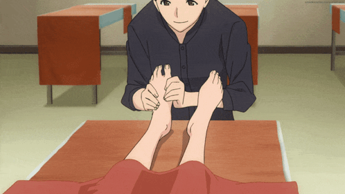 A Man Is Massaging A Woman 'S Feet In A Room GIF