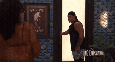 A Man Is Opening A Door In Front Of A Sign That Says " Welcome " GIF