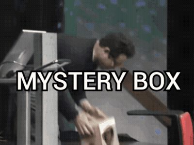 A Man Is Opening A Mystery Box In Front Of A Monitor GIF