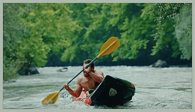 A Man Is Paddling A Kayak With A Yellow Paddle GIF