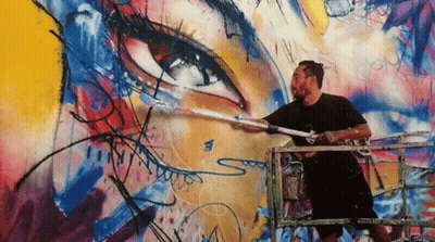 A Man Is Painting A Mural On A Wall With The Letter S On The Bottom GIF