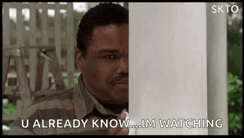 A Man Is Peeking Out From Behind A Porch Post And Saying `` U Already Know ... Im Watching '' . GIF