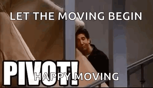 A Man Is Peeking Out From Behind A Wall With A Sign That Says `` Let The Moving Begin '' . GIF
