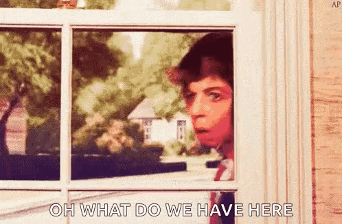 A Man Is Peeking Out Of A Window With The Words `` Oh What Do We Have Here '' Written On It . GIF