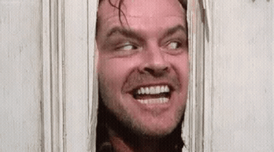 A Man Is Peeking Through A Door With His Mouth Open And Making A Funny Face . GIF