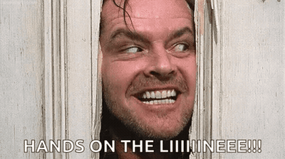A Man Is Peeking Through A Hole In A Door And Smiling . GIF
