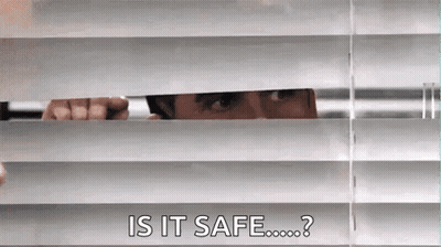 A Man Is Peeking Through The Blinds Of A Window And Asking If It Is Safe . GIF
