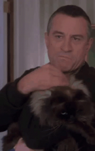 A Man Is Petting A Black Cat On His Head GIF
