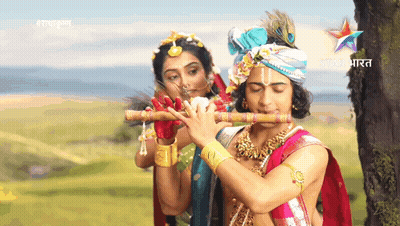 A Man Is Playing A Flute Next To A Woman With The Word Star India On The Bottom GIF