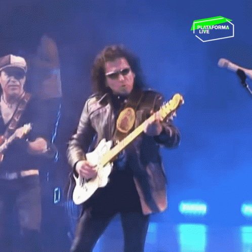 A Man Is Playing A Guitar In Front Of A Sign That Says " Plataforma Live " GIF