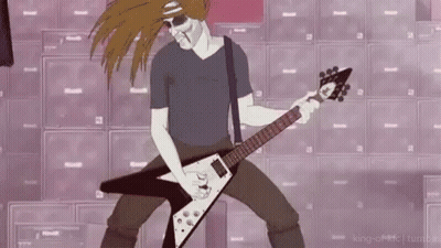 A Man Is Playing A Guitar In Front Of A Wall Of Speakers . GIF