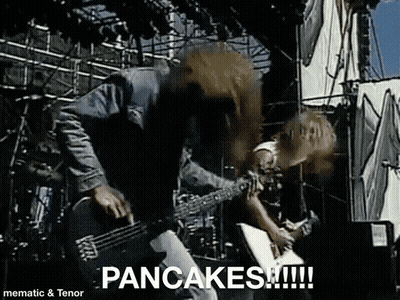 A Man Is Playing A Guitar On A Stage And The Words Pancakes Are On The Screen . GIF