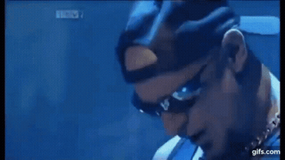 A Man Is Playing A Guitar On A Stage In Front Of A Drum Kit . GIF
