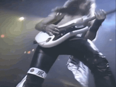 A Man Is Playing A Guitar On A Stage While Wearing A Bandage With Chinese Characters On It . GIF