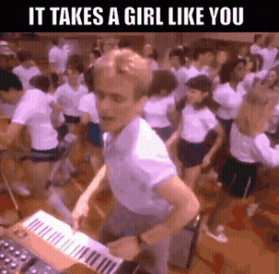 A Man Is Playing A Keyboard In Front Of A Crowd Of People With The Caption It Takes A Girl Like You GIF