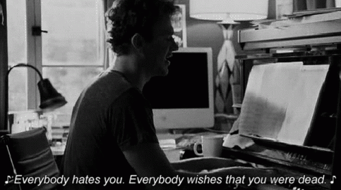 A Man Is Playing A Piano And Says Everybody Hates You Everybody Wishes That You Were Dead . GIF