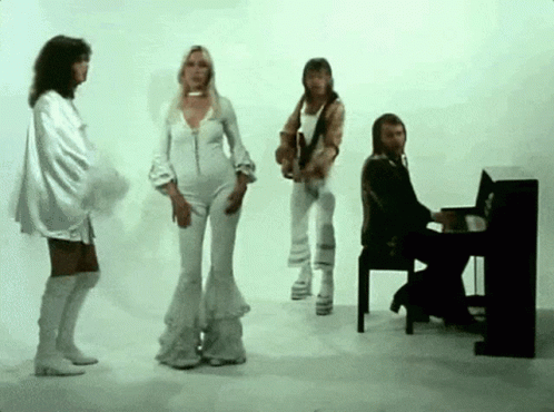 A Man Is Playing A Piano While A Group Of People Are Dancing GIF
