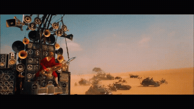 A Man Is Playing A Saxophone In Front Of A Wall Of Speakers In The Desert GIF