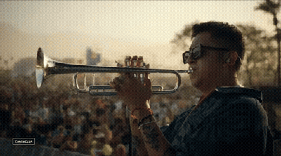 A Man Is Playing A Trumpet In Front Of A Crowd At A Music Festival Called Cancabella GIF