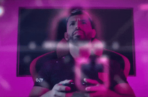 A Man Is Playing A Video Game While Wearing A Shirt That Says ' Ucd ' On It GIF