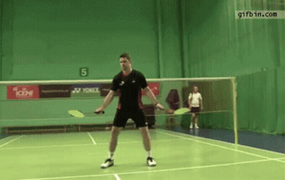 A Man Is Playing Badminton On A Court With A Yonex Advertisement On The Wall GIF
