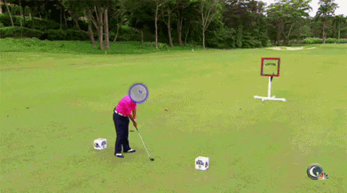 A Man Is Playing Golf On A Lush Green Field With A Sign That Says " Golf " On It GIF