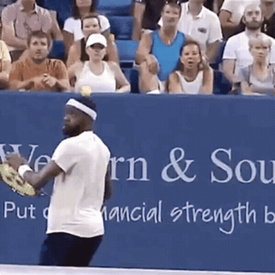 A Man Is Playing Tennis In Front Of A Banner That Says Western & Southern GIF