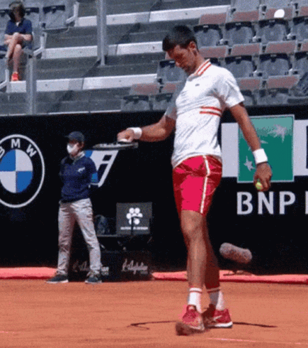 A Man Is Playing Tennis In Front Of A Bnp Ad GIF