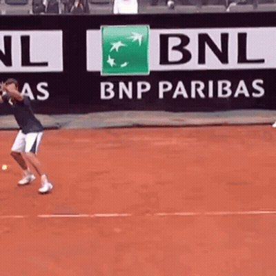 A Man Is Playing Tennis In Front Of A Bnp Paribas Banner GIF