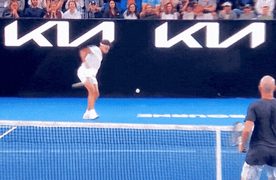 A Man Is Playing Tennis In Front Of A Kia Banner GIF