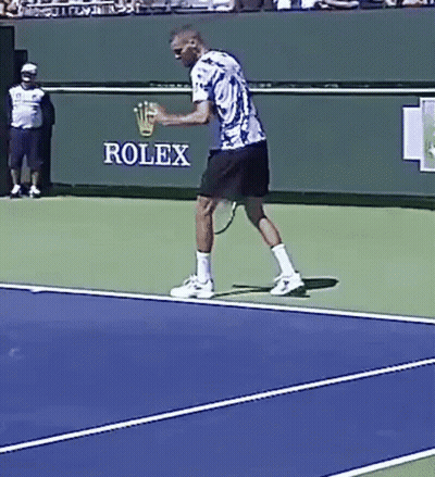 A Man Is Playing Tennis In Front Of A Rolex Banner GIF