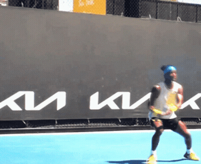 A Man Is Playing Tennis In Front Of A Sign That Says Km GIF
