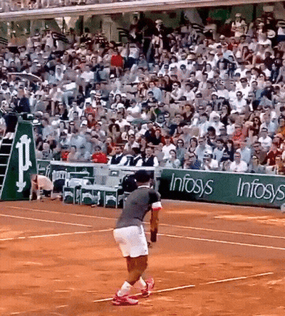 A Man Is Playing Tennis On A Court With A Sign That Says Infosys GIF