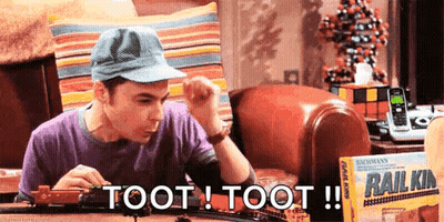A Man Is Playing With A Train Set That Says Toot Toot On It GIF