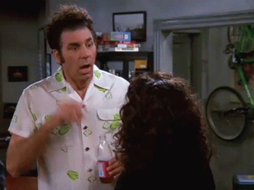 A Man Is Pointing At A Woman Who Is Holding A Coca Cola Bottle . GIF