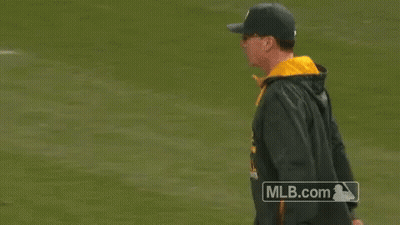 A Man Is Pointing At Something On A Baseball Field With A Mlb.com Logo In The Background GIF