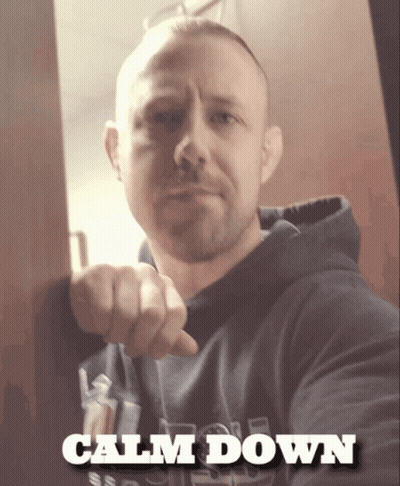 A Man Is Pointing At The Camera And The Words Calm Down Are Above Him GIF