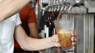 A Man Is Pouring A Drink Into A Glass GIF