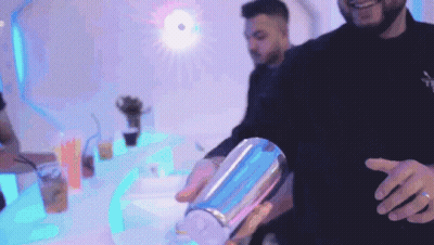 A Man Is Pouring A Drink Into A Shaker GIF