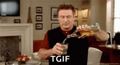 A Man Is Pouring A Glass Of Whiskey From A Bottle In A Living Room . GIF