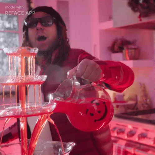 A Man Is Pouring A Red Drink Into A Pitcher With A Smiley Face On It GIF
